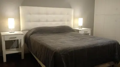 a bedroom with two nightstands with a bed and two lamps at Nueva Córdoba Rondeau in Cordoba