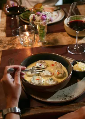 a person holding a fork and a bowl of soup on a table at Posada & Bodega La Matilde in San Javier