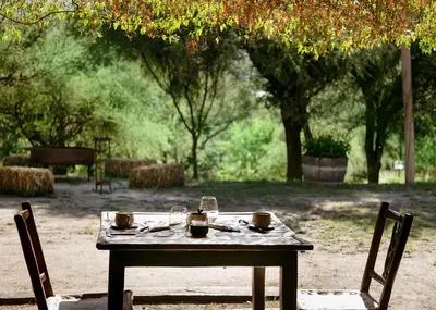 a table with two chairs and a table with drinks on it at Posada & Bodega La Matilde in San Javier