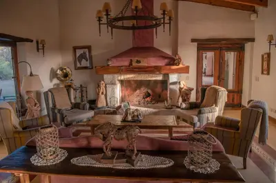 a living room with a fireplace and a table at Posada & Bodega La Matilde in San Javier