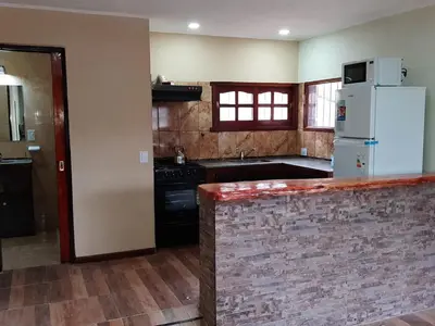 a kitchen with a white refrigerator and a counter at Cabañas Layken in Villa Carlos Paz