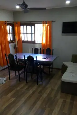 a dining room with a table and chairs and a couch at Cabañas Layken in Villa Carlos Paz