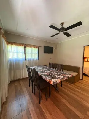 a dining room with a table and a ceiling fan at Cabañas Layken in Villa Carlos Paz