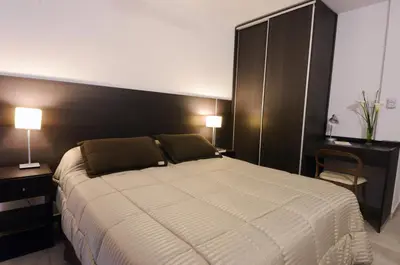 a bedroom with a large bed and two lamps at Corzuelas Aparts - Mina Clavero in Mina Clavero