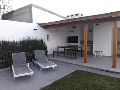 a patio with two chairs and a table and awning at Corzuelas Aparts - Mina Clavero in Mina Clavero