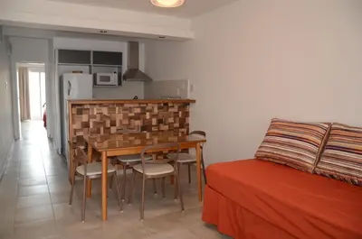 a kitchen with a table and chairs next to a bed at Corzuelas Aparts - Mina Clavero in Mina Clavero