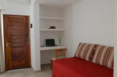 a living room with a couch and a desk with a laptop at Corzuelas Aparts - Mina Clavero in Mina Clavero