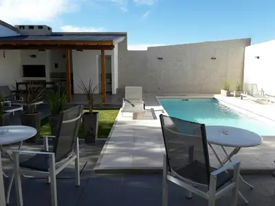 a patio with tables and chairs next to a swimming pool at Corzuelas Aparts - Mina Clavero in Mina Clavero