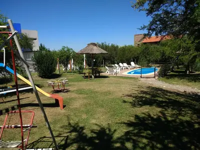 a playground with a slide and a swimming pool at Cabañas Quinco in Merlo