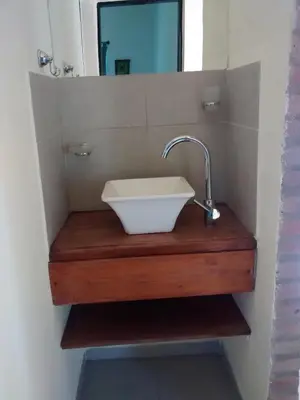 a sink in a bathroom with a mirror at Cabañas Quinco in Merlo