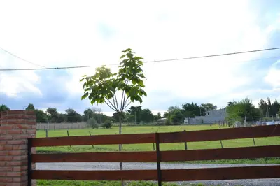 a park with a fence and a tree in a field at Casas Cordoba in Villa Parque Siquiman