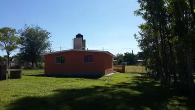 a small red house in a yard with a tree at Casas Cordoba in Villa Parque Siquiman