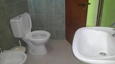 a bathroom with a white toilet and a sink at Casas Cordoba in Villa Parque Siquiman