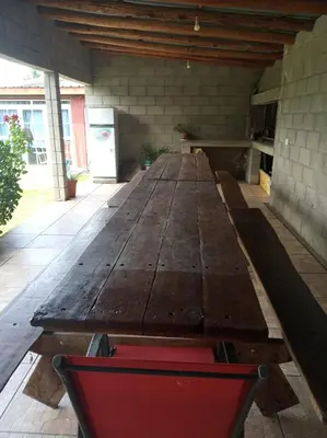 a large wooden table in a room with a red chair at Casas Cordoba in Villa Parque Siquiman