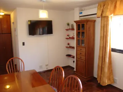 a dining room with a table and chairs and a television at Departamento Maipu Cordoba in Cordoba