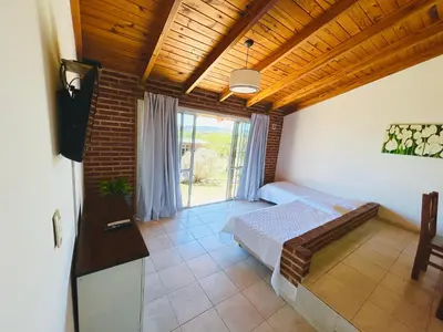 a bedroom with a bed and a large window at Complejo Acanto in Villa Carlos Paz