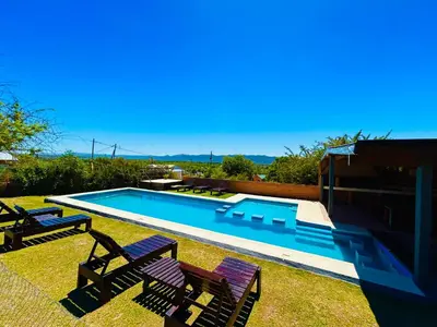 a swimming pool with two lawn chairs at Complejo Acanto in Villa Carlos Paz