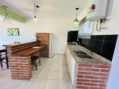 a kitchen with a sink and a brick wall at Complejo Acanto in Villa Carlos Paz
