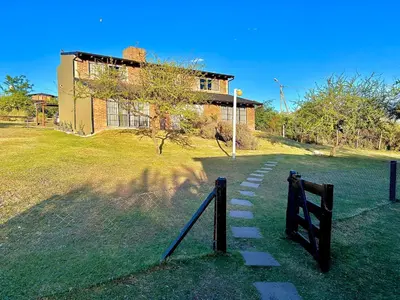 a house on a hill with a path in front of it at Complejo Acanto in Villa Carlos Paz