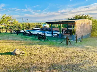 a swimming pool with a pavilion and a picnic table at Complejo Acanto in Villa Carlos Paz