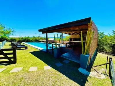 a pavilion with a swimming pool in a yard at Complejo Acanto in Villa Carlos Paz