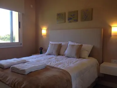 a bedroom with a large bed with white sheets and pillows at Parque Los Nogales Apart Hotel in Merlo