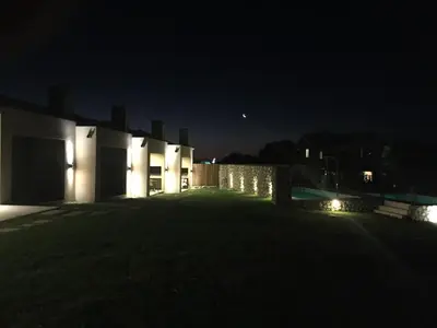 a house at night with the moon in the sky at Parque Los Nogales Apart Hotel in Merlo