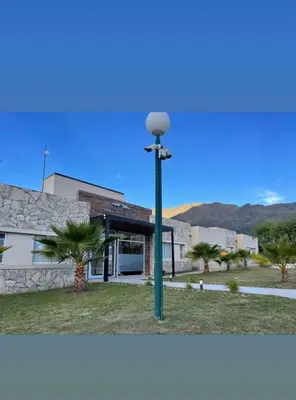 a light pole in front of a building with palm trees at Parque Los Nogales Apart Hotel in Merlo