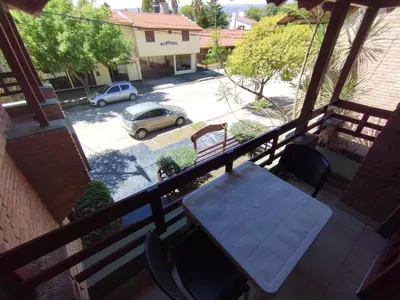 a balcony with a table and a car on a street at Hostería Tejas Negras in Mina Clavero
