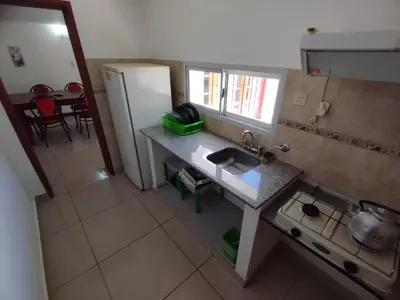 a small kitchen with a sink and a refrigerator at Hostería Tejas Negras in Mina Clavero