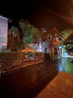 a wooden bench in front of a house at night at Hostería Tejas Negras in Mina Clavero