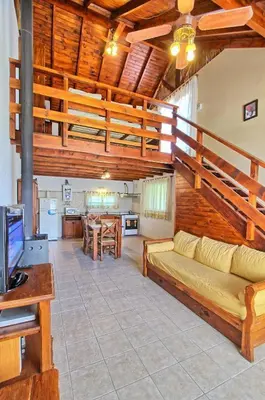 a living room with a couch and a kitchen at Sonnen Haus in Villa General Belgrano