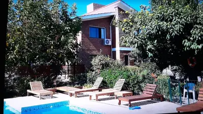 a group of chairs sitting next to a swimming pool at Descanso las Tres Marias Apart Hotel in Villa Carlos Paz