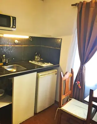 a small kitchen with a stove and a sink at Descanso las Tres Marias Apart Hotel in Villa Carlos Paz
