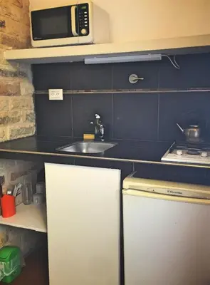 a kitchen with a sink and a microwave at Descanso las Tres Marias Apart Hotel in Villa Carlos Paz