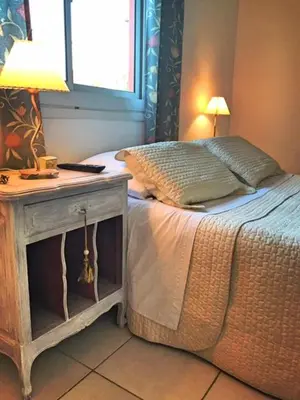 a bedroom with a bed and a table with a lamp at Descanso las Tres Marias Apart Hotel in Villa Carlos Paz