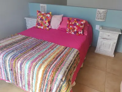 a bed with a colorful blanket and pillows on it at Aires de Ambar in Merlo