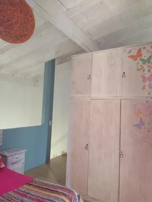 a bedroom with a large wooden cabinet next to a bed at Aires de Ambar in Merlo