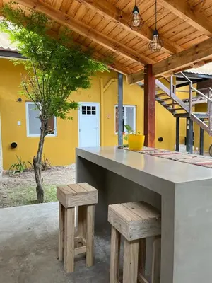 a kitchen with a counter and two stools at Hostel Avetaia in Santa Rosa de Calamuchita