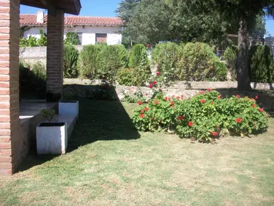 a garden with flowers and a bench in the grass at Cabañas Tio Willy in Villa Carlos Paz