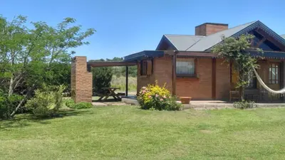 a brick house with a picnic table in a yard at Complejo Tierra Mia in Panaholma