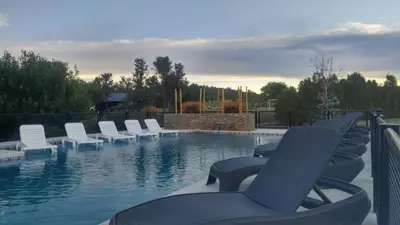 a swimming pool with white chairs and a row at Complejo Tierra Mia in Panaholma