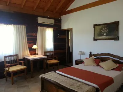 a bedroom with a bed and a table and a desk at Complejo Tierra Mia in Panaholma