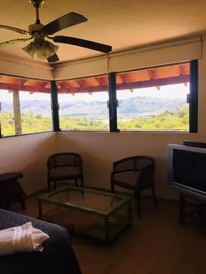 a living room with a view of the mountains through windows at Cañada Al Lago in Villa Parque Siquiman