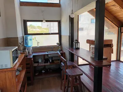 a kitchen with a sink and a desk with a microwave at Cañada Al Lago in Villa Parque Siquiman