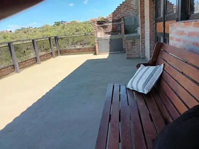 a purse sitting on a wooden bench on a balcony at Cañada Al Lago in Villa Parque Siquiman