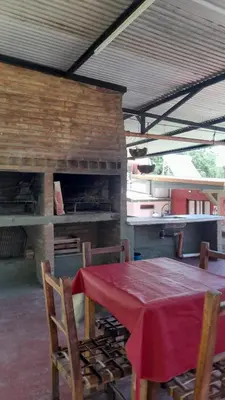 a table and chairs in front of a brick fireplace at Apart Dany in Villa Los Molinos