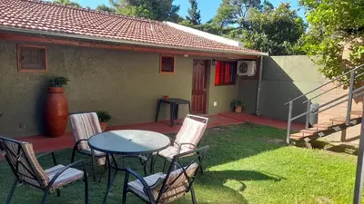 a patio with a table and chairs in front of a house at Apart Dany in Villa Los Molinos
