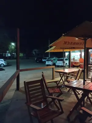 a group of tables and chairs in a parking lot at night at Apart Dany in Villa Los Molinos