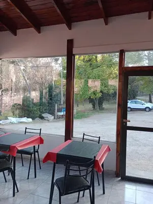 a patio with two tables and chairs and a window at Apart Dany in Villa Los Molinos